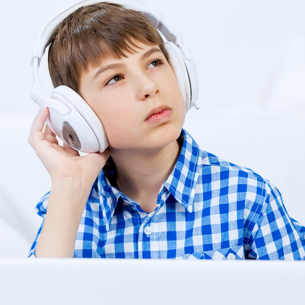 Student listening to headphones and staring off into the distance