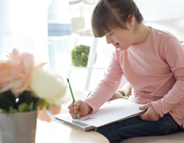 young girl writing on paper