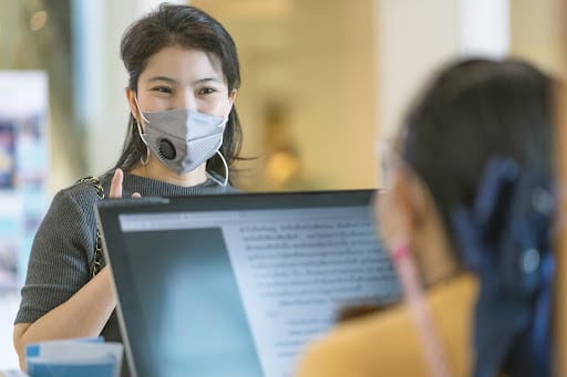 Teacher in Mask looking at student