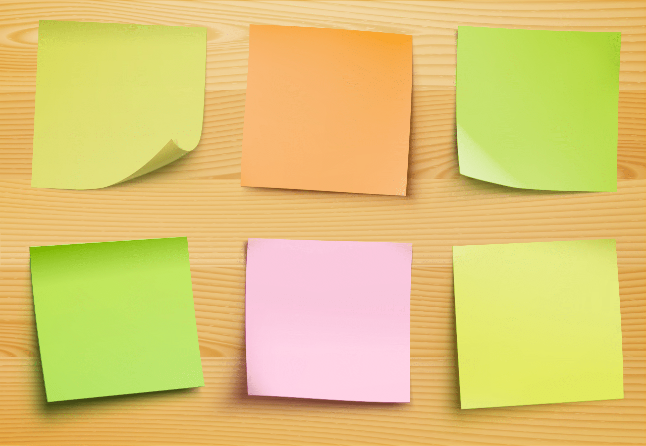 Multi-colored sticky notes on a wood wall.